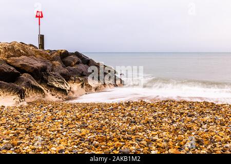 Colour landscape photograph taken from Hengistbury heads pebble beach looking out over calm sea, Dorset, England Stock Photo