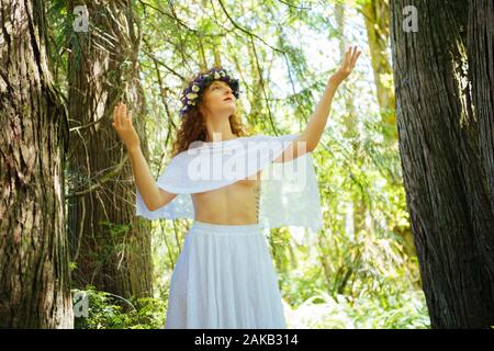 Woman with flower crown posing in forest,  Bainbridge Island, Washington State, USA Stock Photo