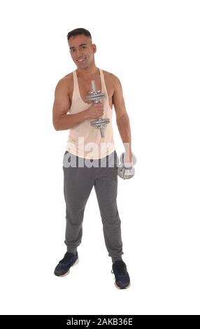 A handsome east Indian man standing in track pants working with two dumbbells, isolated for white background Stock Photo