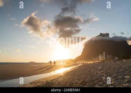 A golden sunset from Sao Conrado Beach in the city of Rio de Janeiro, Brazil, with Pedra da Gavea. Stock Photo