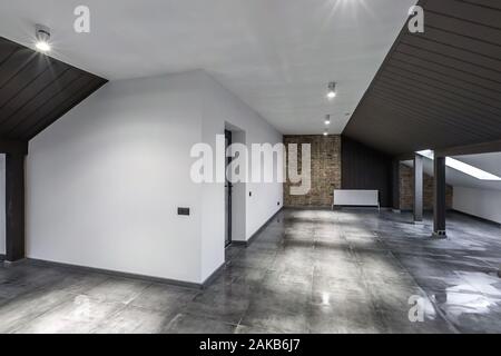 Empty unfurnished loft mansard room interior with wooden columns and wet concrete floor on roof level in black and whote style color Stock Photo