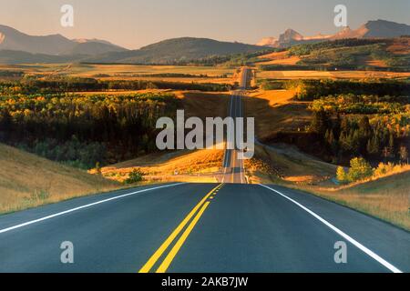 Landscape with country road in valley at sunset, Pincher Creek, Alberta, Canada Stock Photo