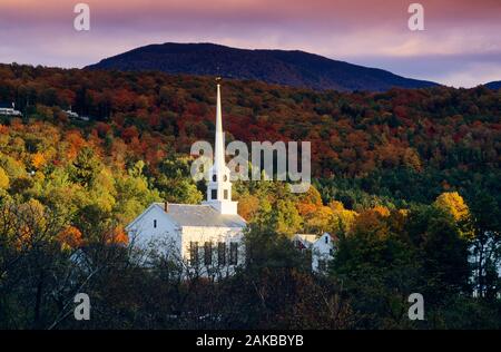 Church and forest on mountainside in autumn, Stowe, Vermont, USA Stock Photo