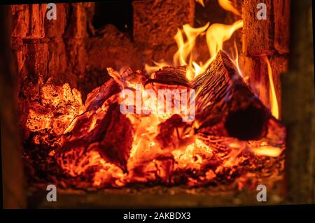 Burning firewood and coals in a stone stove. Pizza oven. Brick oven on wood. Stock Photo