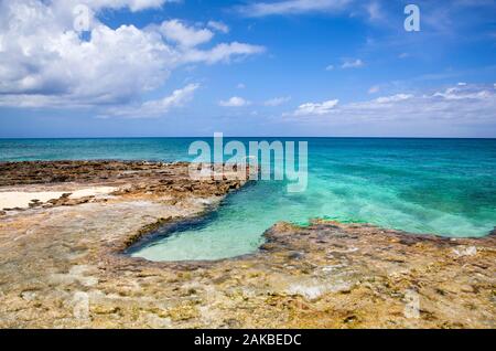 The rocky landscape with a ladder on Grand Cayman island Seven Mile Beach (Cayman Islands). Stock Photo