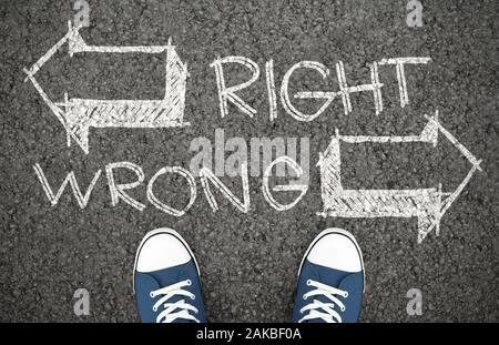 Doubt Concept. Difficult decision between right and wrong way, correct or incorrect path. Chalk drawing on road Stock Photo