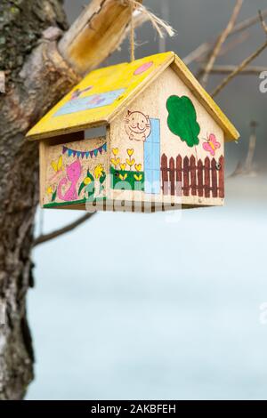 Feeding station for birds in shape of a house, beautiful paintings made by a child Stock Photo