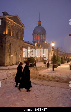 People walking in a snowing evening with Bonsecours Market in the background.Old Montreal.Montreal.Quebec province.Canada Stock Photo