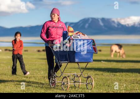 Kyrgyzstan, Naryn province, Son-Kol lake, altitude 3000m, woman walking with a stroller in the steppe Stock Photo