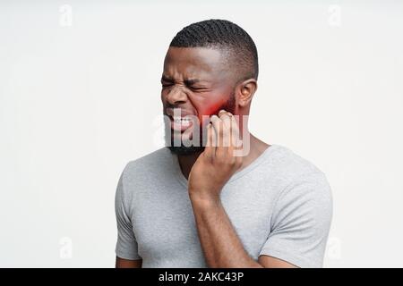 Young black man having wisdom teeth problem, suffering from acute toothache Stock Photo