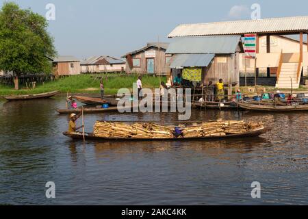 Benin, lakeside city of Ganvié, wood merchant on her dugout Stock Photo