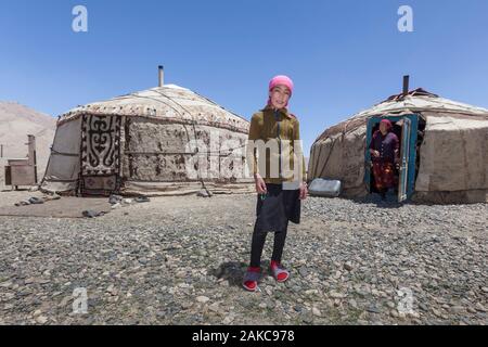 Tajikistan, Gorno-Badakhshan Autonomous Region, Yurt camp by M41 road, also called Pamir Highway, Kyrgyz girl posing in front of yurts and mother in the background, altitude 3900m Stock Photo