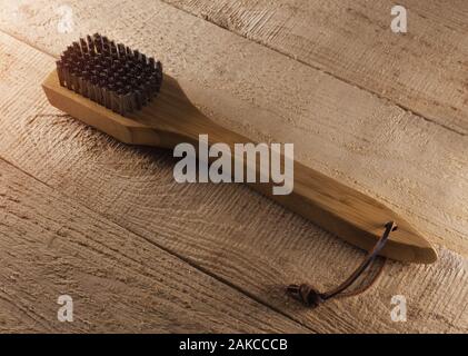 Barbecue grill cleaning brush on rustic wood background. Stock Photo