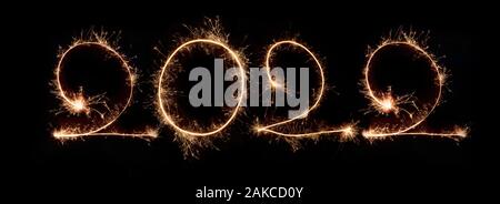Happy New Year 2022. Number 2022written sparkling sparklers isolated on black background With Copy Space For Text. Beautiful Glowing overlay template Stock Photo