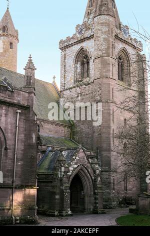 Large square tower & clock face of Brechin Cathedral, Angus, Scotland, UK. with arch Gothic windows & uncommon Irish style round tower in background,. Stock Photo