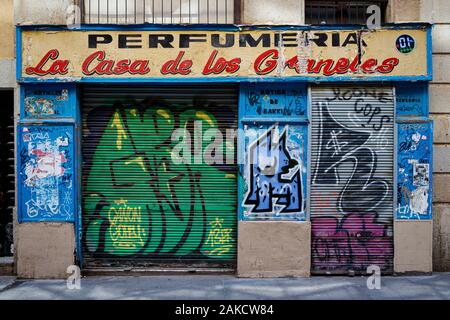 Closed down and disused Perfumeria, La Casa Los Graneles, graffiti and defacement on the shutters and walls. Barcelona, Spain. Stock Photo