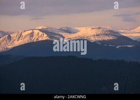 Landscape in early spring. The mountain peaks are covered with snow. Morning sunlight. Carpathian Mountains. Ukraine Stock Photo