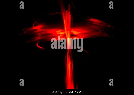 Red colored crucifix like light painting abstract background on a black background. Stock Photo