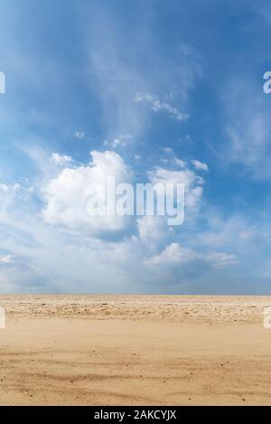 Beach landscape with yellow sand and blue sky with clouds, Summer heat background. Summer vacay at the beach. Desert and sky. Sunny beach day. Stock Photo
