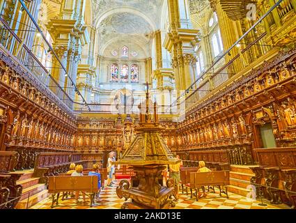 MALAGA, SPAIN - SEPTEMBER 26, 2019: The complex carved wooden choir of Cathedral with fine relief patterns and sculptures of the Saints, on September Stock Photo