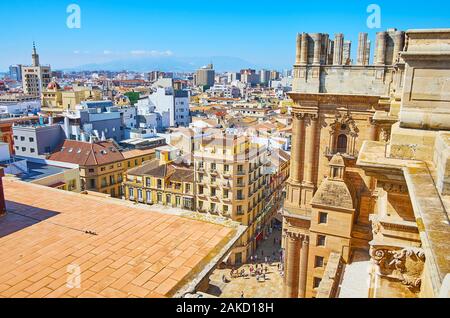 Malaga Cathedral roof observes unfinished stone right bell tower, rising over the city roofs, Andalusia, Spain Stock Photo