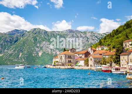 Scenic panorama view of the historic town of Perast at famous Bay of Kotor on a beautiful sunny day with blue sky and clouds in summer, Montenegro Stock Photo