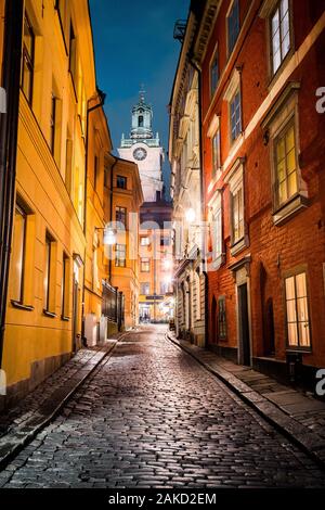 Classic twilight view of tradtional houses in beautiful alleyway in Stockholm's historic Gamla Stan (Old Town) illuminated during blue hour at dusk Stock Photo