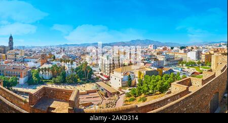 MALAGA, SPAIN - SEPTEMBER 26, 2019: Panorama of Malaga, surrounded by mountains, with medieval Alcazaba ramparts on the foreground and old town distri Stock Photo