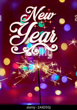 Happy new year.Glittering burning sparkler on red and color bukeh  background Stock Photo