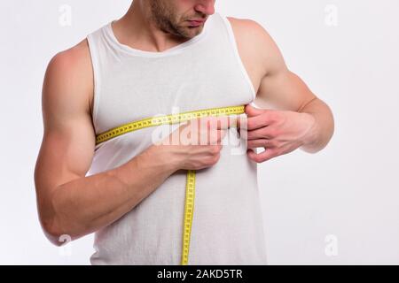 Image of muscular man measure his biceps with measuring tape in centimeters  Stock Photo - Alamy