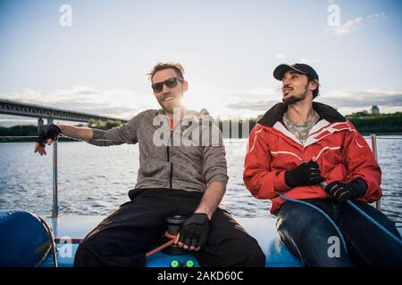 Two happy man resting after fishing on yacht. Stock Photo