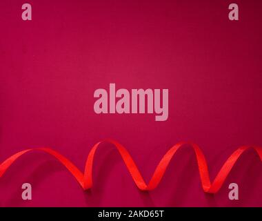 Red ribbon on pink fabric Stock Photo