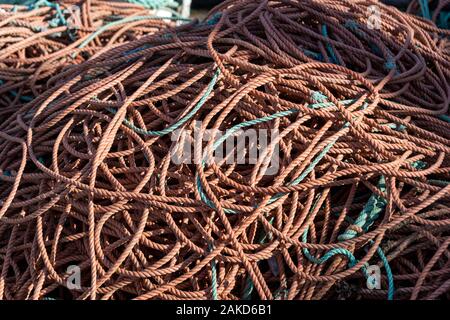 piles of orange nylon rope on thr harbourside, rope used for netting in the fishing industry. Stock Photo