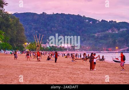 PATONG, THAILAND - MAY 1, 2019: People came to meet the sunset on the central beach of resort, on May 1 in Patong Stock Photo
