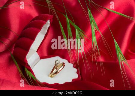 gold ring in box on red black backgroung Stock Photo