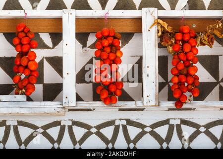 Tomatoes drying on a traditionally decorated wall of a house in Pyrgi village on Chios island, Greece. Stock Photo