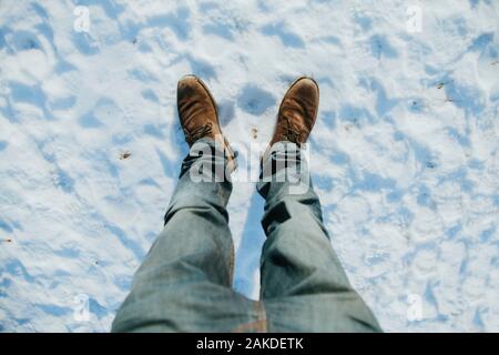 Close Up Of Male Legs In Winter Shoes Standing On the Snow Stock Photo