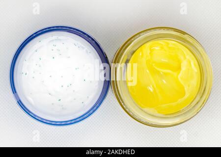 white cream in a jar and yellow cream in a jar, cosmetology, self-care, beauty, cosmetology top view Stock Photo
