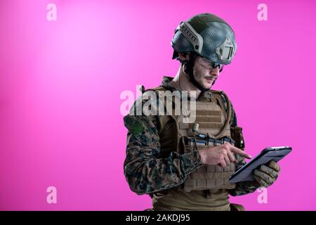 soldier using tablet computer hands closeup pnk background Stock Photo