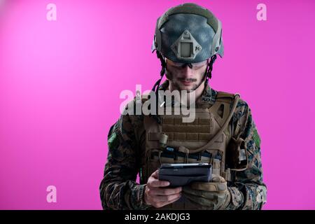 soldier using tablet computer hands closeup pnk background Stock Photo