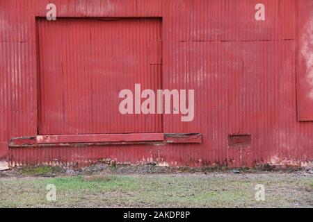 red sliding barn door old abandoned farm building Stock Photo