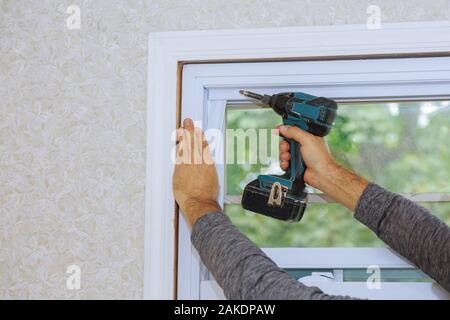 Process of worker installing new plastic pvc window man using a screwdriver Stock Photo