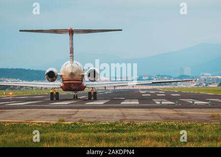 A McDonnell Douglas MD-83, of the now-defunct Far Eastern Air Transport, lines up for takeoff on Songshan Airport's runway one evening Stock Photo