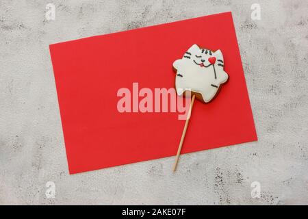 Decorated cookies on red sheet for your text . Gingerbread cookies in the form of a cat . Place for text. Concept valentines day. Card Stock Photo