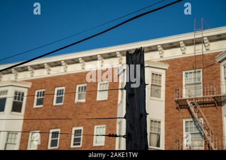 Broken wooden power cable tower with wires in residential neighborhood Stock Photo