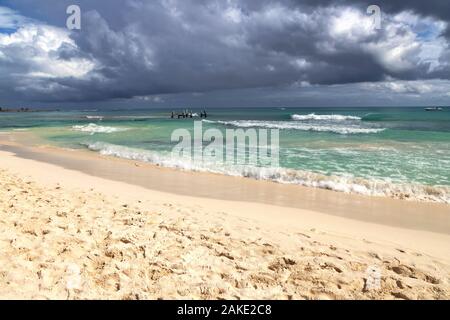 Dark clouds form over the sea with waves crashing the beach as storm approaches. Stock Photo