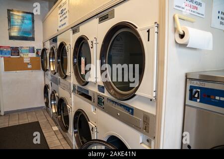 Rows of washing and drying machines at a laundromart Stock Photo