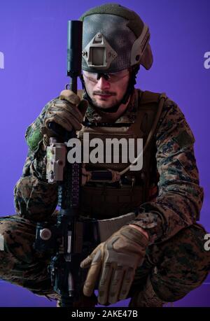 sad soldier has psychological problems holding his head in a squatting position Stock Photo