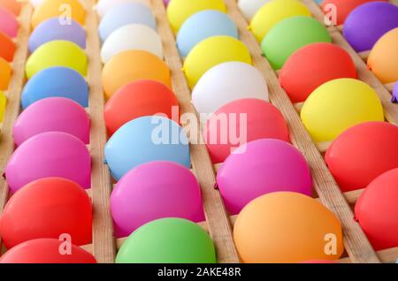 Colorful balloons as targets. Wall of colored balloons with some popped, carnival game. Stock Photo