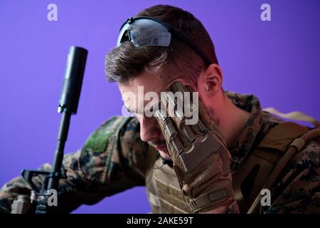 sad soldier has psychological problems holding his head in a squatting position Stock Photo